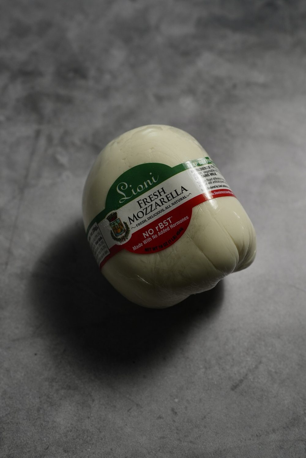 A 1 lb ball of Lioni fresh mozzarella, no rBST, in its wrapper.
