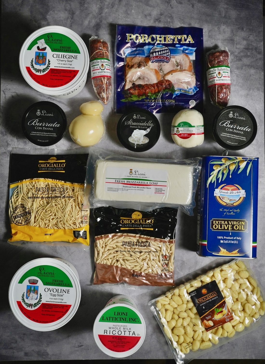 An order laid out: Lioni fresh mozzarella in ciliegine, ovoline and loaf, burrata con panna, stracciatella, whole-milk ricotta, Cioli porchetta and soppressata, Oro Giallo fresh pasta and gnocchi, and a tin of Gerardo Di Nola olive oil.